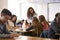 Female High School Teacher Standing By Student Table Teaching Lesson