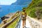 Female hiker go down and descent the pathway with spectacular landscape of Capri, Naples, Italy