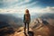 Female hiker at mountain peak overlooking vast landscape