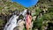 Female hiker near wild splashing waterfall. Ayous lake french Pyrenees