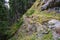 Female hiker passing narrow passage on a hike.