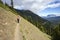 Female hiker with pole on mountain ridge path