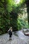 Female hiker poses before a creek crossing in Fern Canyon Hike in Redwood National Park California