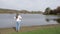 Female hiker reaching the edge of a pond, admiring the scenery