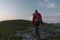 Female hiker silhouette walking the trail uphill, at sunset