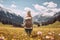 Female hiker standing in flowering alpine meadow and admiring a scenic view from a mountain top. Adventurous young girl with a