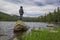 Female hiker standing on a rock in an alpine lake