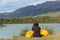 Female hiker stays warm with blankets while looking at beautiful mountain landscape