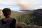 A female hiker stops to look at an impending bushfire from a high vantage point in the Blue Mountains National Park, Australia