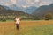 Female hiker is trekking in alpine countryside landscape in autumn