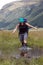 Female hiker wading thru a creek while tramping in New Zealand