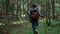 Female hiker walking in woods. Young woman with backpack trekking in forest
