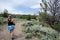 Female hiker walks on a dirt hiking trail in Miners Delight Wyoming to explore a ghost town