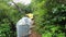 Female hikers with raincoats climb the old forest path\\\'s stone steps on a rainy day