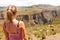 Female hiking tourist at the edge of a cliff overlooking the canyons