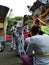 the female hindu priest is giving the people sprinkling holy water after they have finished praying