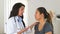 Female hispanic doctor advises asian patient