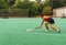 Female hockey player attacking and hitting on a grass field