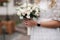 Female hold bouquet of white roses in hands. Mini wedding. Blond hair bride with bouquet of flowers