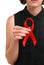 A female holding red ribbon isolated on a white background. Modern treatment and healthcare. AIDS awareness concept.