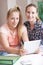 Female Home Tutor Helping Girl With Studies Using Digital Tablet