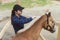 Female Horse Owner Brushing Mane Of Her Light Brown Horse In The Horse Farm