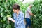 Female horticulturist checking unripe fruits of tomatoes in hothouse