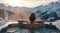 female in hot tub overlooking mountains and snow