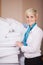Female Housekeeper Stacking Sheets In Stock Room