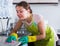 Female houseworker with rag and cleanser indoors