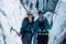 Female ice climbers with ice axes in front of a large crevasse. Happy people smiling while active outdoors