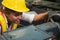 Female industrial worker working and checking machine in a large industrial factory with many equipment