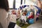 Female infant school teacher sitting on a chair showing a book to a group of children sitting on bean bags in a comfortable corner