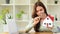 Female inspector using magnifying glass examining a house model.House selection, real estate appraisal and house search