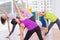 Female instructor guiding friends in stretching exercise