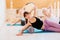 Female instructor with young female and senior woman together using a foam roller for a myofascial release massage at