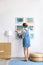 Female interior designer decorating white wall with pictures