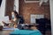 Female interior designer wearing protective mask holding a blueprint while working on new poject, sitting at the table