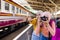 Female Islamic tourists take fun photos on the train platform while waiting for their journey