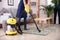 Female janitor hoovering carpet in flat