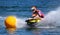 Female Jet Ski  race competitor cornering at speed creating at lot of spray.