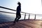 Female jogger morning exercise on seaside boardwalk during sunrise