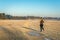 Female jogger runs across the frozen grass