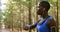 Female jogger using smartwatch in the forest 4k