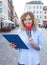 Female journalist with microphone in the city