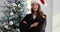 Female judge in Santa Claus hat holds gavel against the background of Christmas tree