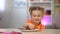 Female kid secretly taking chocolate from white plate on table, sugar overdose