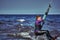 A female kiter slides on the surface of the water. Splashes of water fly apart.