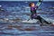 A female kiter slides on the surface of the water. Splashes of water fly apart.