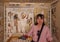 Female Korean tourist and fresco in the south wing end wall of the transverse chamber of TT69 featuring worship of Osiris.